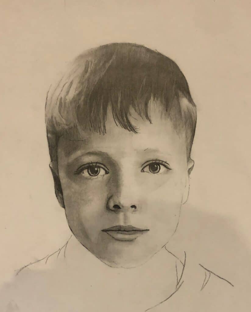A pencil drawing of a young boy with short hair, wide eyes, and a neutral expression, shown from the shoulders up on a plain background. The portrait is detailed, especially around the face and eyes.